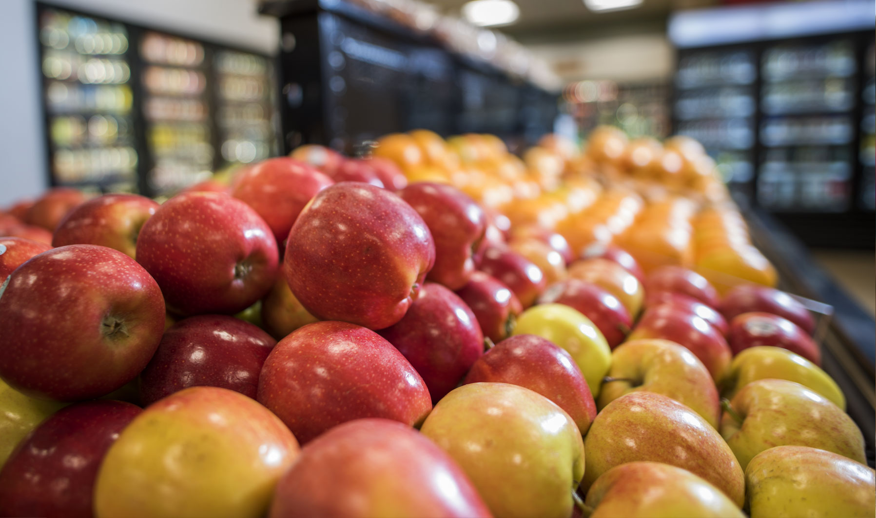 Stacks of fresh apples and oranges.